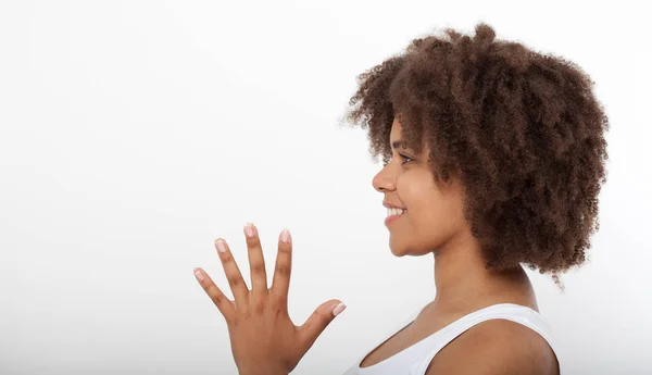 Retrato de una hermosa modelo afroamericana sonriente aislada sobre blanco. Atractiva morena de piel oscura mujer en una camiseta blanca . — Foto de Stock