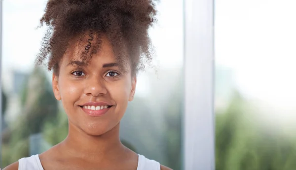 Retrato de una hermosa modelo afroamericana sonriente. Atractiva morena de piel oscura mujer en una camiseta blanca . —  Fotos de Stock