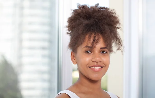 Retrato de una hermosa modelo afroamericana sonriente. Atractiva morena de piel oscura mujer en una camiseta blanca . — Foto de Stock