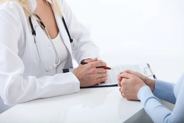 Arzt und Patient diskutieren etwas, nur die Hände am Tisch aus nächster Nähe — Stockfoto
