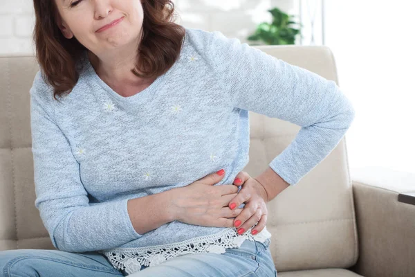 Midden leeftijd vrouwelijke gevoel pijn in de zijkant — Stockfoto