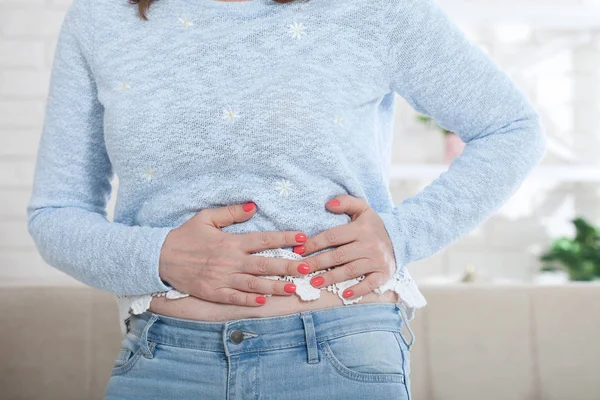 Mulher de meia-idade que sofre de dor abdominal em casa — Fotografia de Stock