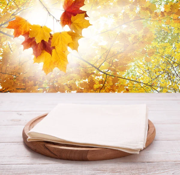 Pizza board with towel on wooden desk. Autumn background. Top view mock up. Selective focus. — Stock Photo, Image