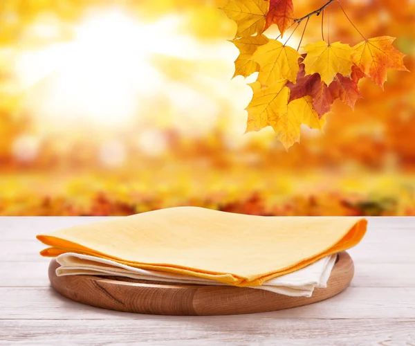 Pizza základní deska s ručníkem na dřevěné desce. Podzim na pozadí. Mock-up pohled shora. Selektivní fokus. — Stock fotografie