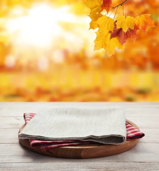 Napkin. Stack of colorful dish towels on wooden table and autumn background. Top view mock up — Stock Photo, Image