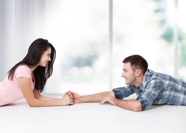 幸福的年轻夫妇坐在地板上抬头看着, 同时梦想着他们的新家和家具。模拟一下 — 图库照片