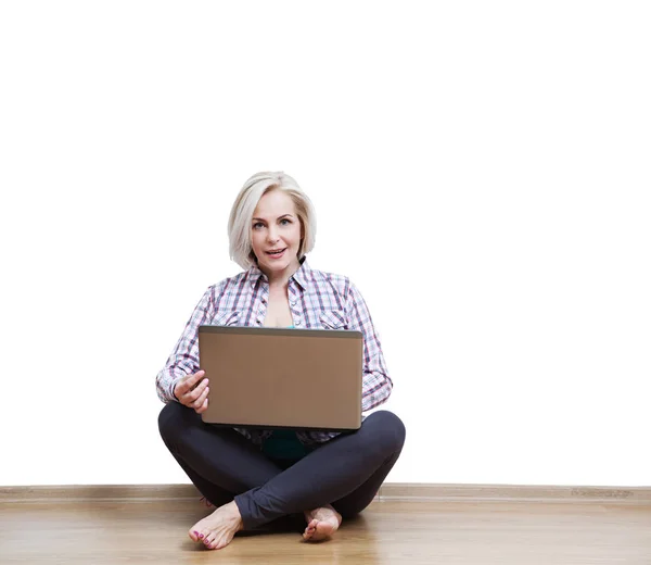 Smiling beautiful middle-aged woman sitting on the floor with la — Stock Photo, Image