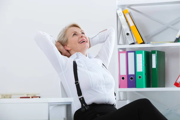 Kobieta, relaks na krześle i cieszyć się widok z pakietu office. — Zdjęcie stockowe