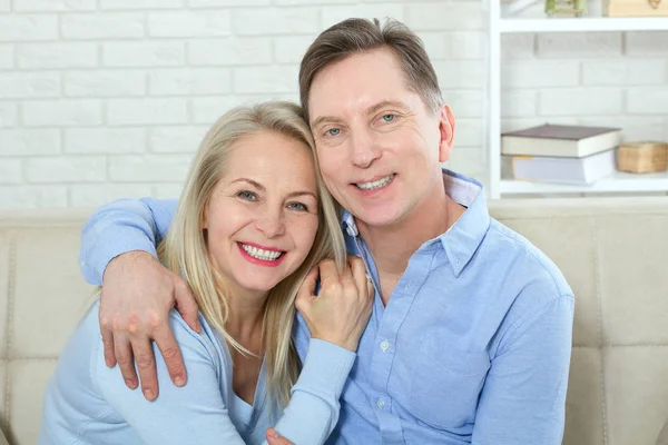 Pareja Mediana Edad Relajándose Sofá Sonriendo Cámara Casa Sala Estar — Foto de Stock