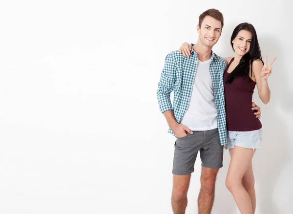 Feliz pareja abrazando y mirando a la cámara en el fondo blanco — Foto de Stock