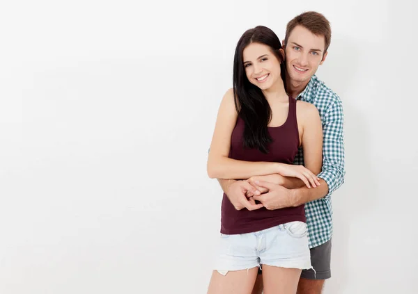 Glückliches Paar umarmt und blickt Kamera auf weißem Hintergrund — Stockfoto