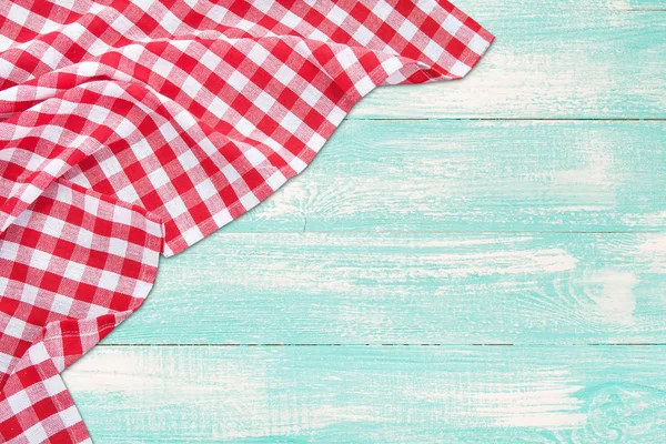 Vintage wooden table with red checkered tablecloth. Top view mockup.