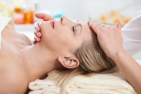 Massagem facial no spa macro. Mulher atraente com olhos fechados cuidando da pele. Massagem enfrentar foco seletivo . — Fotografia de Stock