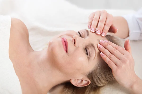 Retrato de mujer hermosa en ambiente spa. mujer de mediana edad haciendo masaje facial en un salón de spa —  Fotos de Stock