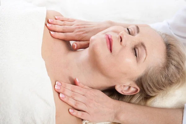 Massagem facial no spa macro. Mulher atraente com olhos fechados cuidando da pele. Massagem enfrentar foco seletivo . — Fotografia de Stock