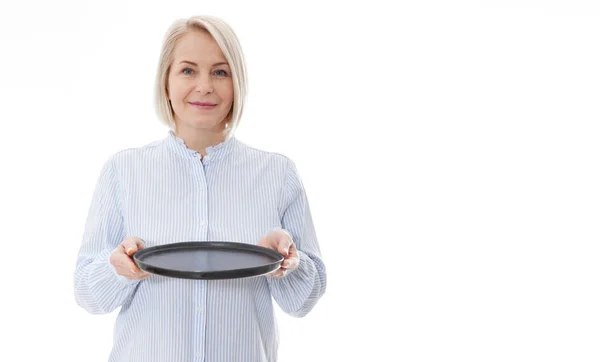 Keuken vrouw geeft lege zwarte plaat voor uw reclame producten geïsoleerd op witte achtergrond. Mock up voor gebruik — Stockfoto