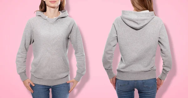 Conception de chemise et concept de mode - jeune femme en sweat-shirt gris devant et derrière, sweat à capuche gris, blanc isolé sur fond rose — Photo