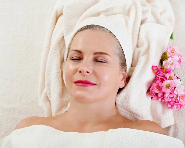 Massaggio viso in spa macro. Donna attraente con occhi vicini che si prende cura della pelle. Massaggio viso selettivo focus . — Foto Stock
