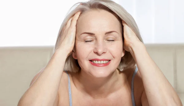 Mujer de 50 años está muy contenta con su rostro bien cuidado. Inyecciones de colágeno de cirugía plástica. Cara de macro. Enfoque selectivo en la cara. Imágenes realistas con sus propias imperfecciones . —  Fotos de Stock