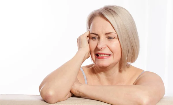 Porträtt av glada äldre kvinna ler medan du tittar bort på spa. Glad mogen kvinna efter spamassage och anti-aging behandling i ansiktet. Realistiska bilder med sina egna brister. — Stockfoto