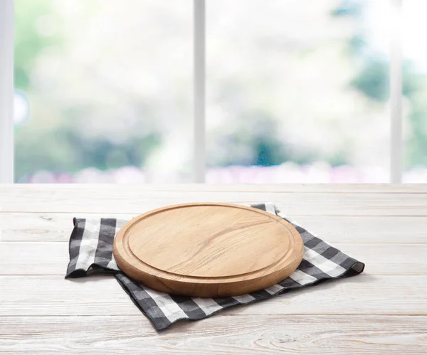 Lege pizzabord en tafelkleed op houten dektafel met servet. Keuken achtergrond. — Stockfoto