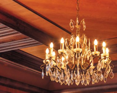 Tavanda ahşaptan yapılmış kristal bir avizenin yakın çekimi..