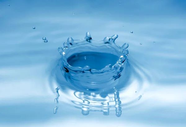 Tröpfchen spritzen auf Wasseroberfläche — Stockfoto