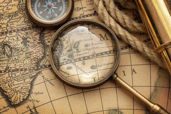 antique compass, spyglass on map