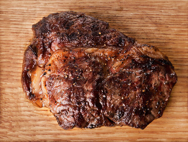 Close-up view of grilled beef steak on wooden background