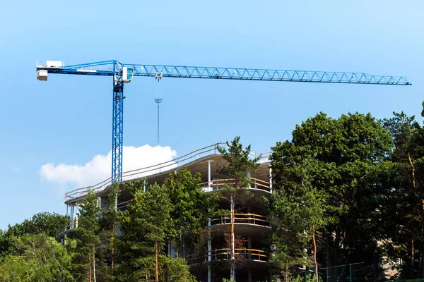 Blue construction crane on a coastal construction site.