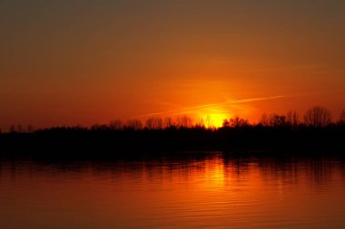 Gölde gün batımı. Güzel kırmızı gökyüzü. ışık oyunu