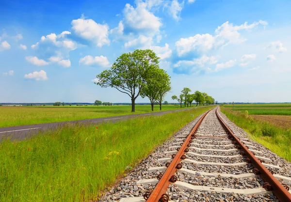 Field with railway rails, roads and blue sky. Landscape of the periphery. — Stock Photo, Image