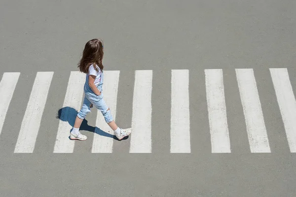 In the summer on the street at the pedestrian crossing kid girl in fashion clothes cross the road — Stock Photo, Image