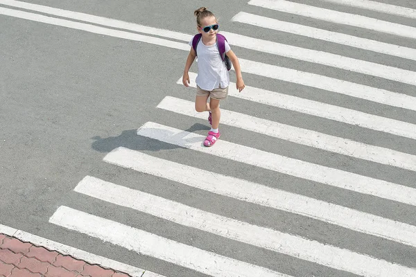 Liseli kız okula giderken karşıdan karşıya geçiyor. Zebra trafiği şehrin öbür ucunda. Yaya geçidinden geçen yayalar. Sırt çantasıyla gezen şık bir genç kız. Aktif çocuk. Üst görünüm