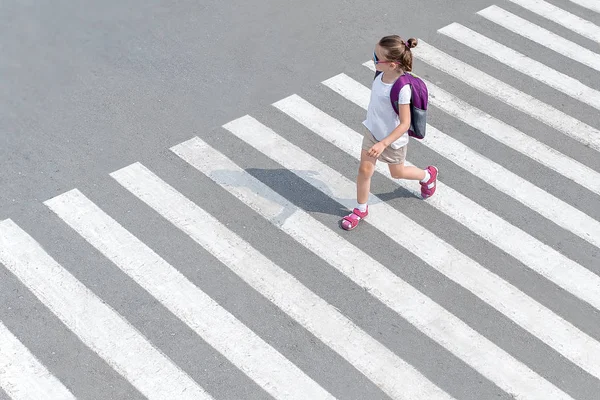 Colegiala cruzando la calle de camino a la escuela — Foto de Stock