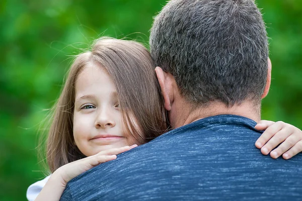 Портрет милой маленькой девочки в объятиях отца. Счастливая семья — стоковое фото