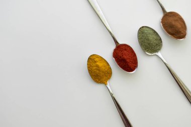 Kaşıklar üzerine düzenlenmiş çeşitli renkli baharatlar 