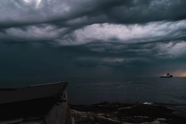 A cargo ship underneath stormy clouds — Stock Photo, Image