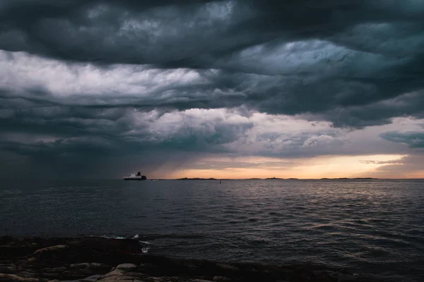 A cargo ship underneath stormy clouds — Stock Photo, Image