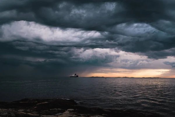 A cargo ship underneath stormy clouds — Stock Photo, Image