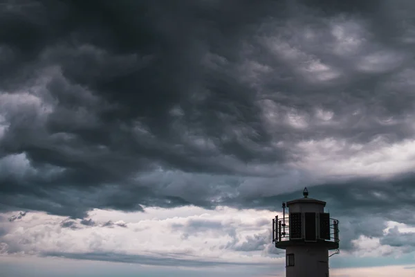 Un faro frente a nubes tormentosas — Foto de Stock