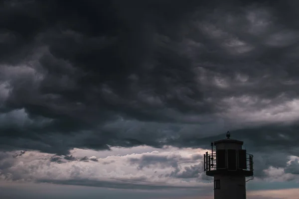 Un faro frente a nubes tormentosas — Foto de Stock