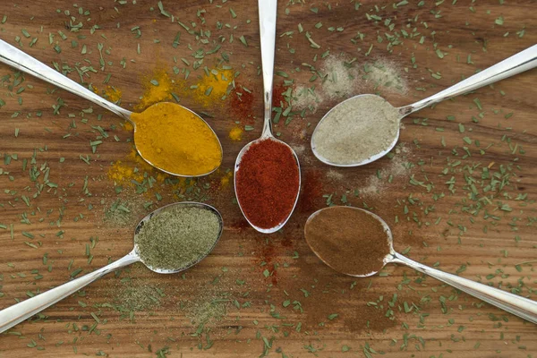 Various colorful spices arranged on spoons — Stock Photo, Image