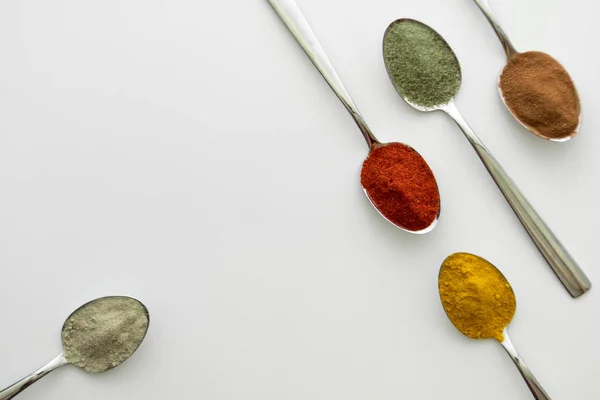 Diverses épices colorées disposées sur des cuillères — Photo