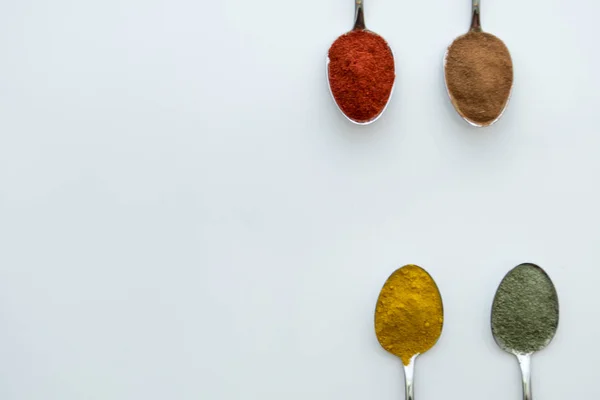 Various colorful spices arranged on spoons — Stock Photo, Image