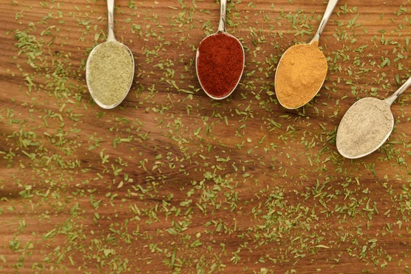 Különböző színes fűszerek elrendezett kanalak — Stock Fotó
