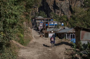 Genç bir kız küçük bir dağ köyüne giriyor, Annapurna pisti, Nepal