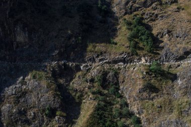 Manang, Annapurna pisti, Nepal yolunda dik bir kenara doğru giden iki araba.