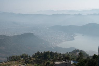 Pokhara şehri, göl ve yuvarlanan tepeler üzerindeki yamaç paraşütçüleri, Sarangkot tepesinden Nepal, Aralık 2019