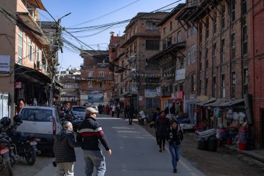 Bhaktapur, Katmandu, Nepal - 23 Aralık 2019: Tanımlanamayan kişiler sokakta yürüyor, motosikletler ve arabalar 23 Aralık 2019 